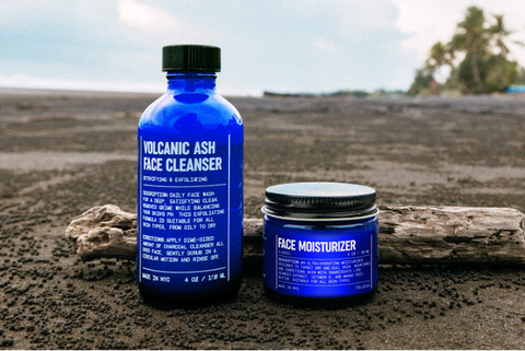 Image of volcanic cleanser and moisturizer in blue bottles with earthy background.