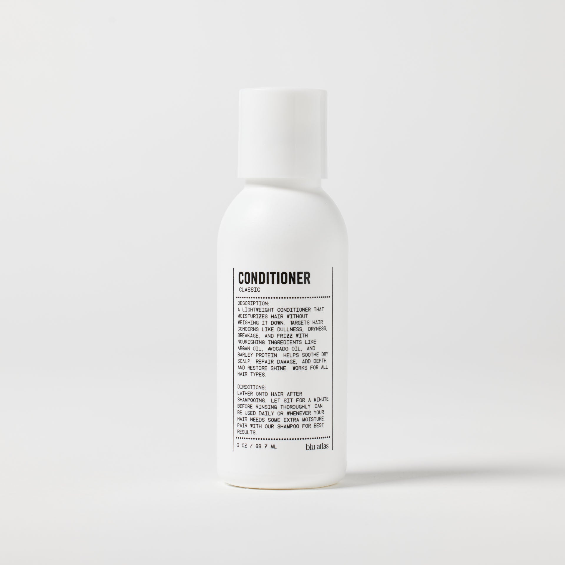 A white bottle of Blu Atlas Travel Size Lightweight Hydrating Conditioner with a printed label, featuring nourishing ingredients, is shown against a plain background.