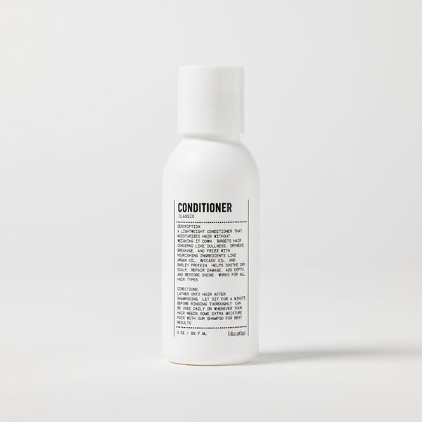 A white bottle of Blu Atlas Travel Size Lightweight Hydrating Conditioner with a printed label, featuring nourishing ingredients, is shown against a plain background.
