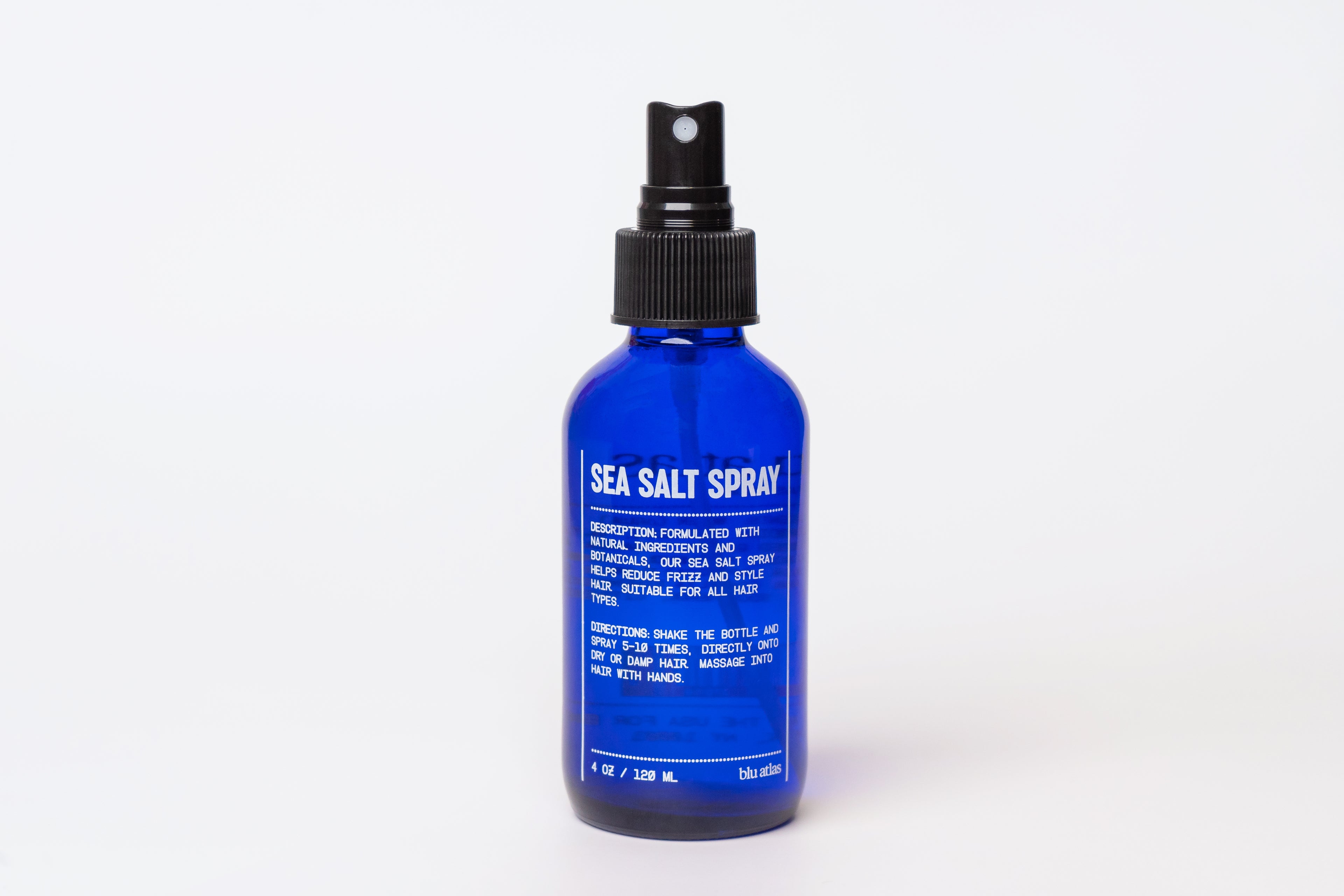 A blue bottle of Blu Atlas Sea Salt Spray, made with natural ingredients, showcases a black spray nozzle and crisp white text on the label, set against a plain white background.