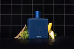 A bottle of Bountiful Eau de Parfum by Blu Atlas, with its enchanting fragrance of lemon peel and greenery, stands elegantly against a black tiled background.
