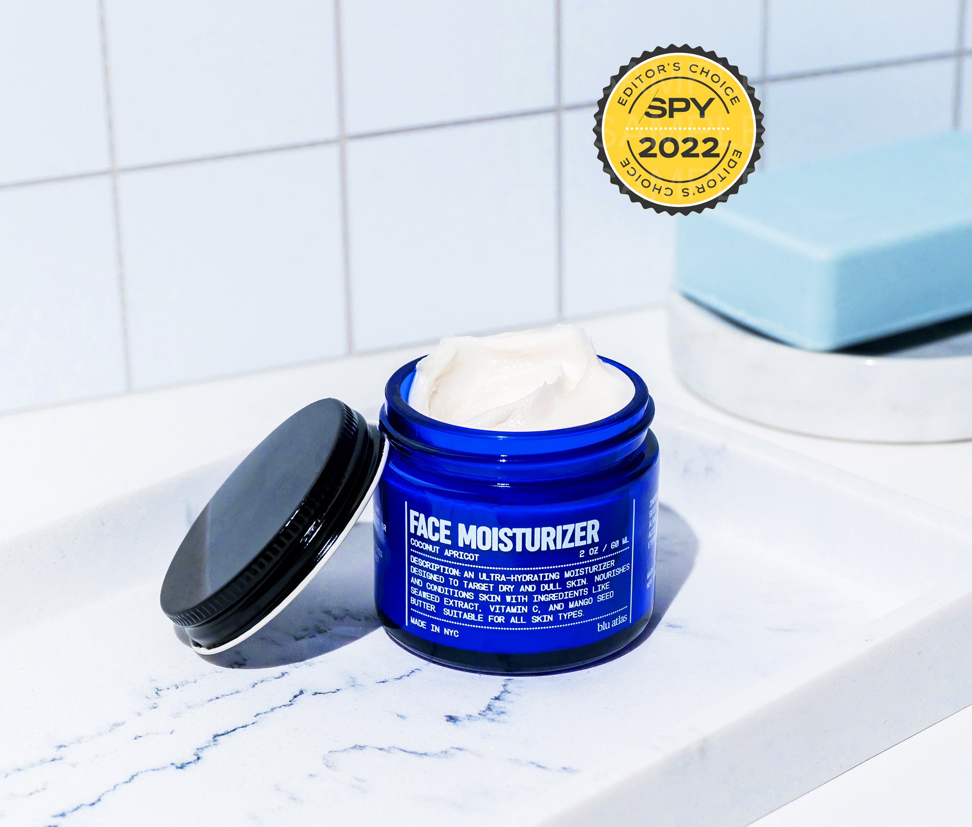 Blu Atlas Hydrating Face Moisturizer, enriched with seaweed extract, sits open on a white countertop beside a blue bar of soap. A 2022 Editors’ Choice SPY award badge gleams in the top right corner.
