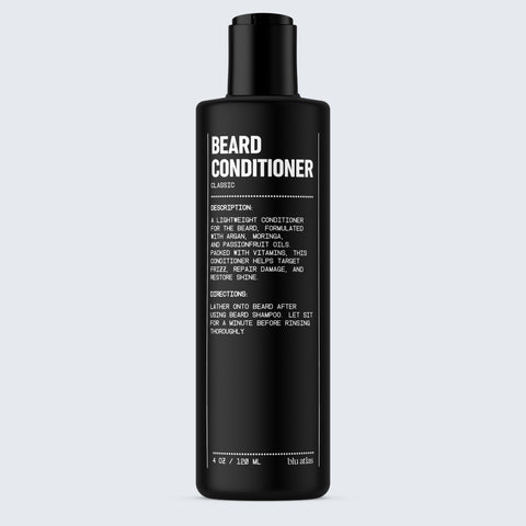 A stylish black bottle of Blu Atlas Beard Conditioner, infused with nourishing Argan Oil, showcases white text that outlines the ingredients and instructions aimed at repairing damage and promoting healthier facial hair.