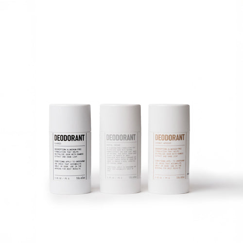 The Deodorant Discovery Set by Blu Atlas showcases three deodorant sticks, each encased in a sleek white cylindrical container with unique labels. They emit a refreshing tropical aroma accented with bergamot notes and are beautifully presented against a pristine white background.