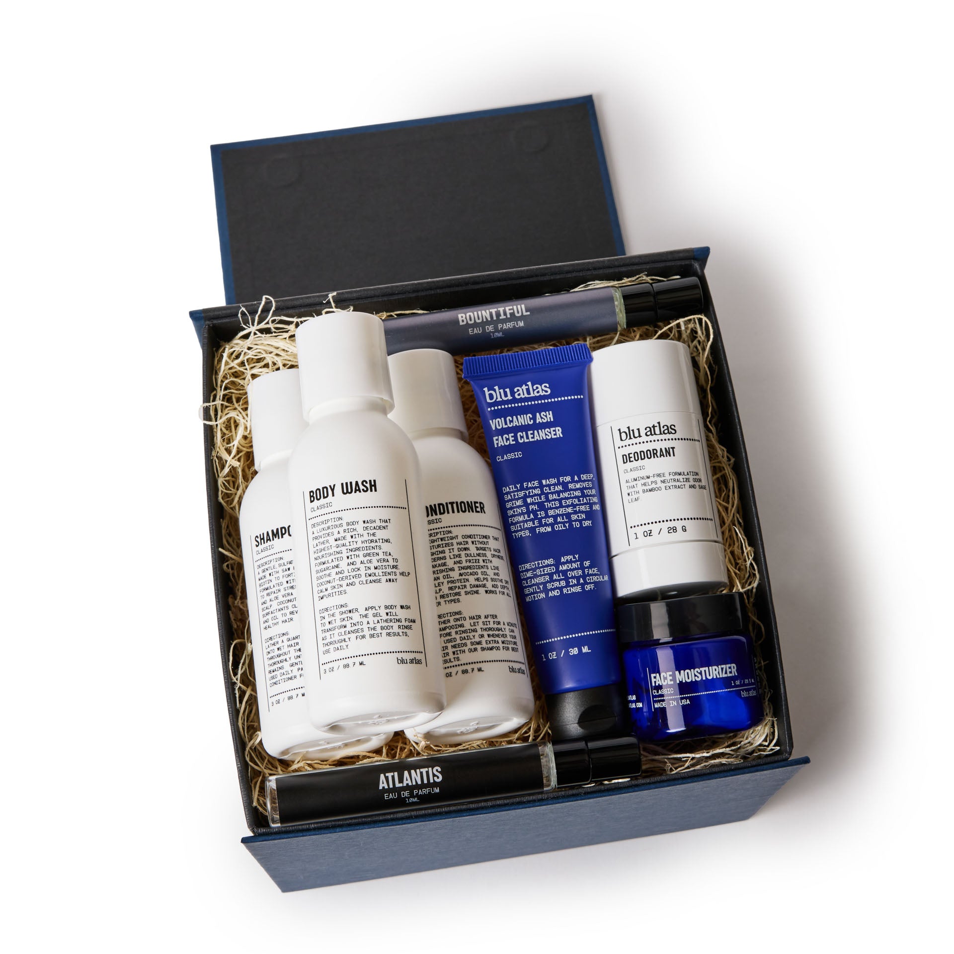 Explore the exclusive Mini MVP Grooming Essentials Bundle by Blu Atlas, presented in a sophisticated blue box. Inside, you'll find shampoo, body wash, and conditioner, accompanied by mini MVPs such as deodorant and cleanser tubes, plus moisturizer and cologne—all beautifully arranged in straw packaging.