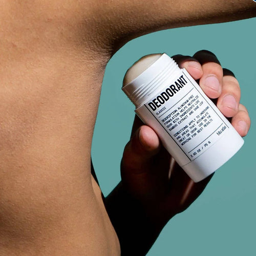 A person applies Blu Atlas 48-Hour Natural Deodorant - Fragrance Free to their underarm against a plain blue-green background.