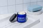 An open jar of Blu Atlas Face Essentials (Cleanser + Moisturizer) is shown.