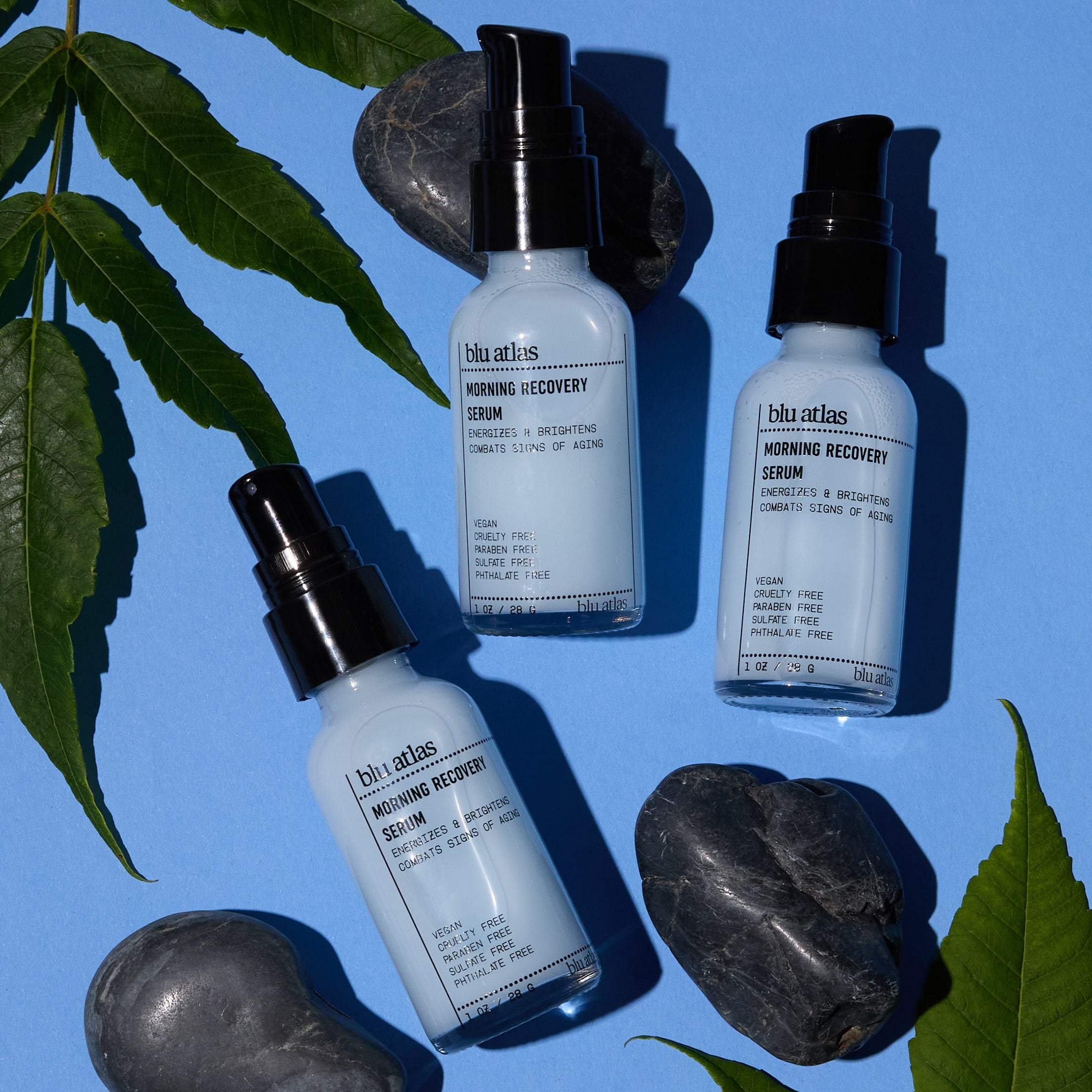Blu Atlas Morning Recovery Serum Trio on Blue Background with Leaves