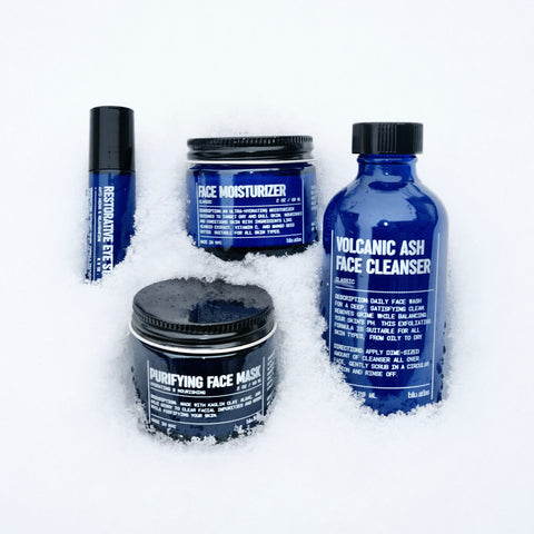 image of bundle of Blu Atlas products in snow including the restorative eye stick, face moisturizer, face cleanser, face mask