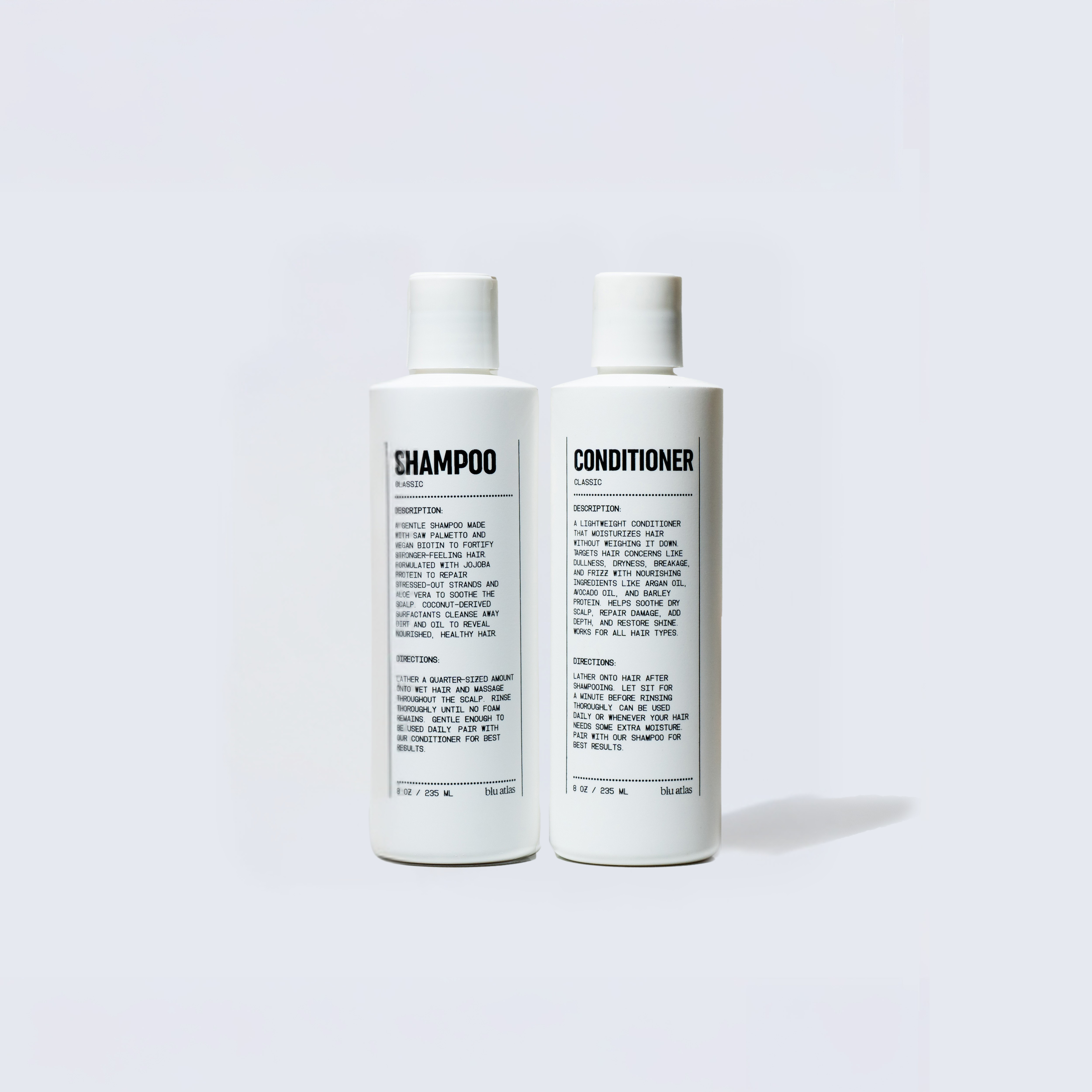 Two white Blu Atlas Hair Essentials bottles, one labeled Shampoo and the other Conditioner, stand upright against a plain light background, highlighting their clean ingredients.