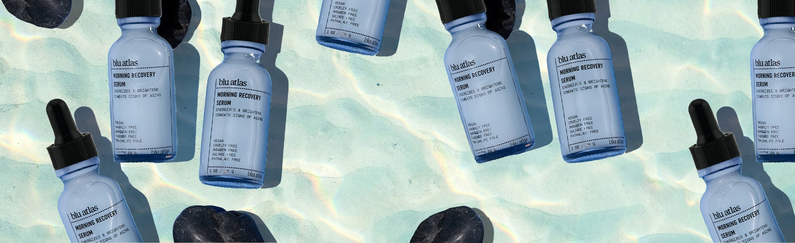 Multiple bottles of a Morning Recovery Serum with droppers on a light blue gradient background