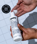 Natural shampoo for all hair types white bottle being squirted on hand.
