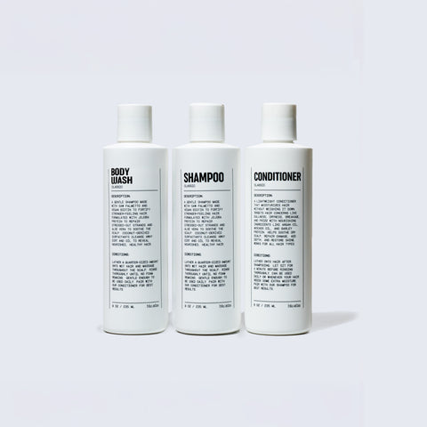 Three white bottles on a gray background labeled by Blu Atlas as Add Hair & Skin Favorites: body wash, shampoo, and conditioner. Each includes black text with descriptions and directions, forming the perfect shower essentials trio for your hair and body bundle.