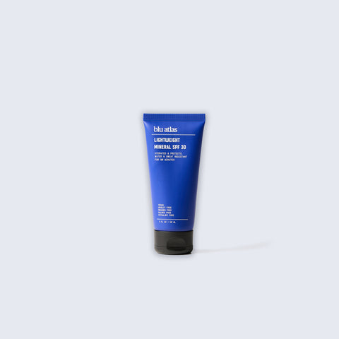 Against a light gray background, a blue tube of Blu Atlas Add Sun Protection, an all-natural SPF 30 sunscreen, stands elegantly.