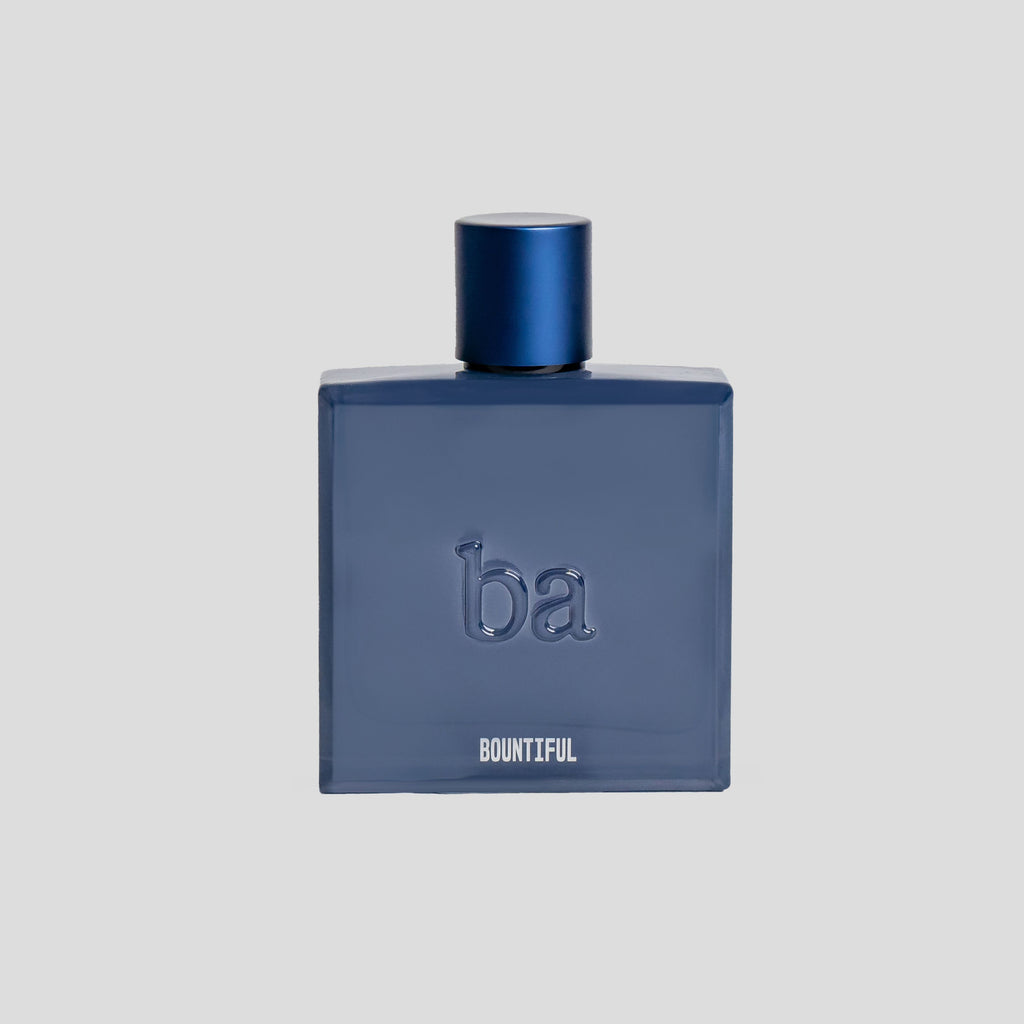 A dark blue perfume bottle labeled ba BOUNTIFUL