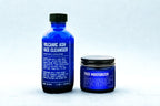 Blue bottles of Volcanic Ash Face Cleanser and Face Moisturizer on a light gray background