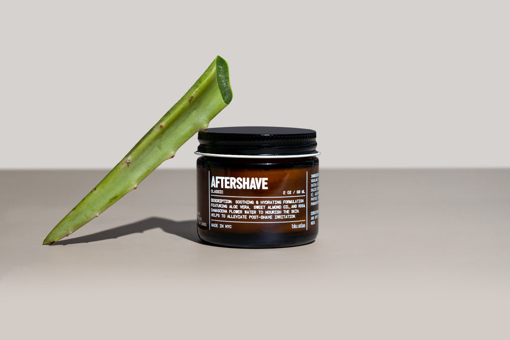 Jar of aftershave with aloe vera leaf on a neutral background