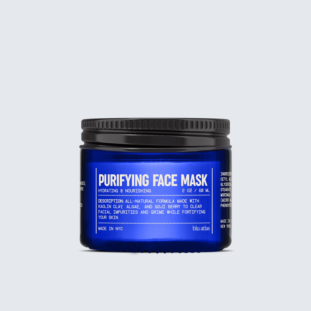 A blue jar labeled Blu Atlas Purifying Face Mask with white text, featuring product details and a black screw-on lid, is centered against a light gray background. This rejuvenating formula combines the benefits of goji berry and kaolin clay for a clearer, more refined complexion.