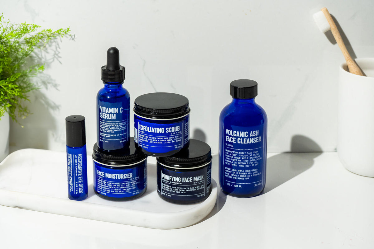 Collection of Blu Atlas skincare products including Volcanic Ash Face Cleanser on a white surface with a light gray background.