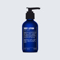 A blue pump bottle of Blu Atlas Body Essentials (Wash + Lotion) featuring white text with usage instructions and ingredients, perfect for daily body care, set against a light gray background.