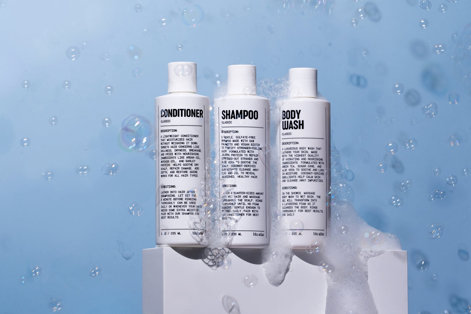 trio of shampoo, bodywash and conditioner surrounded by bubbles