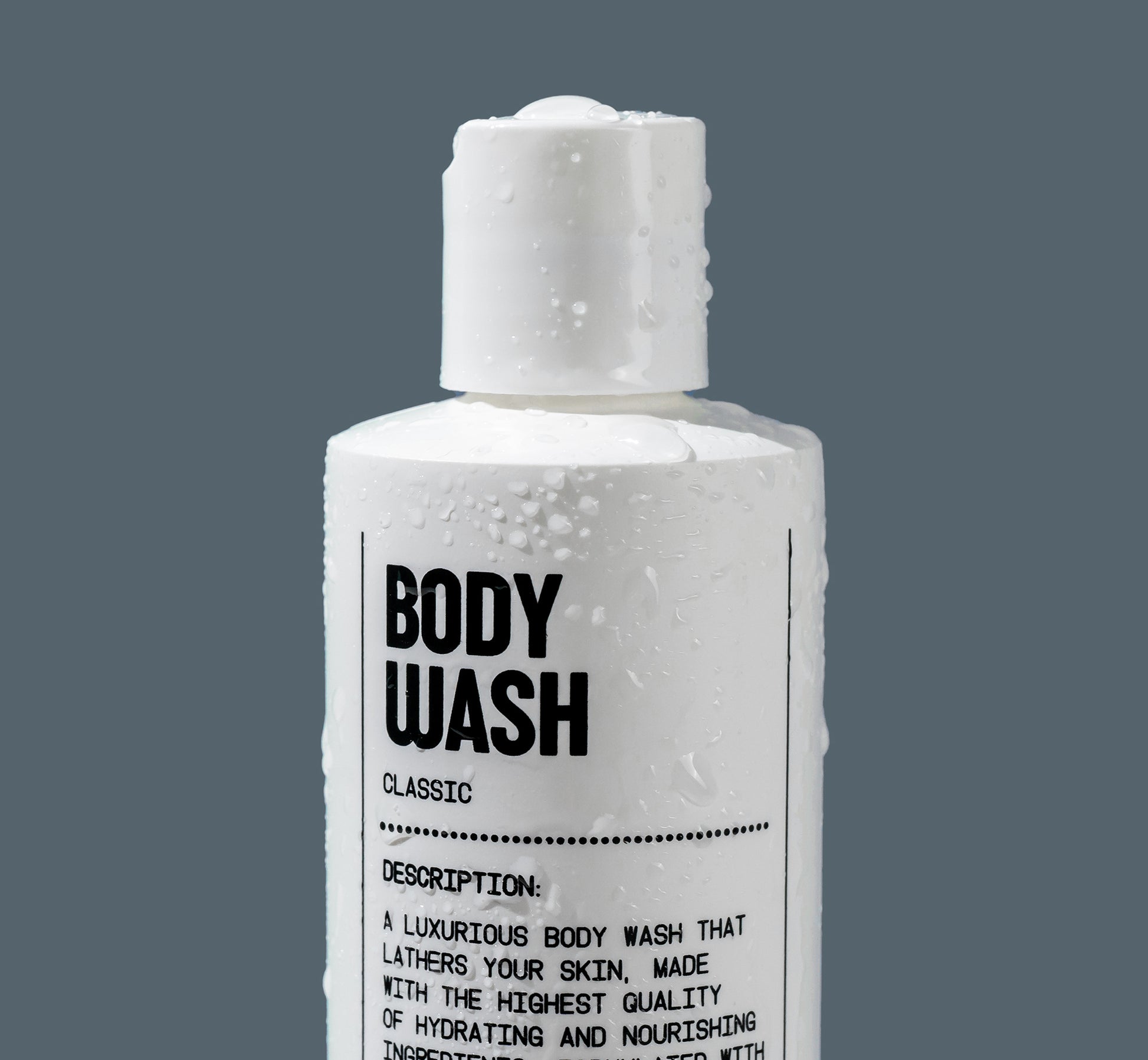A white bottle labeled Hydrating Body Wash by Blu Atlas, adorned with water droplets against a gray background, describes a luxurious formula enriched with coconut-derived emollients for nourishing hydration.