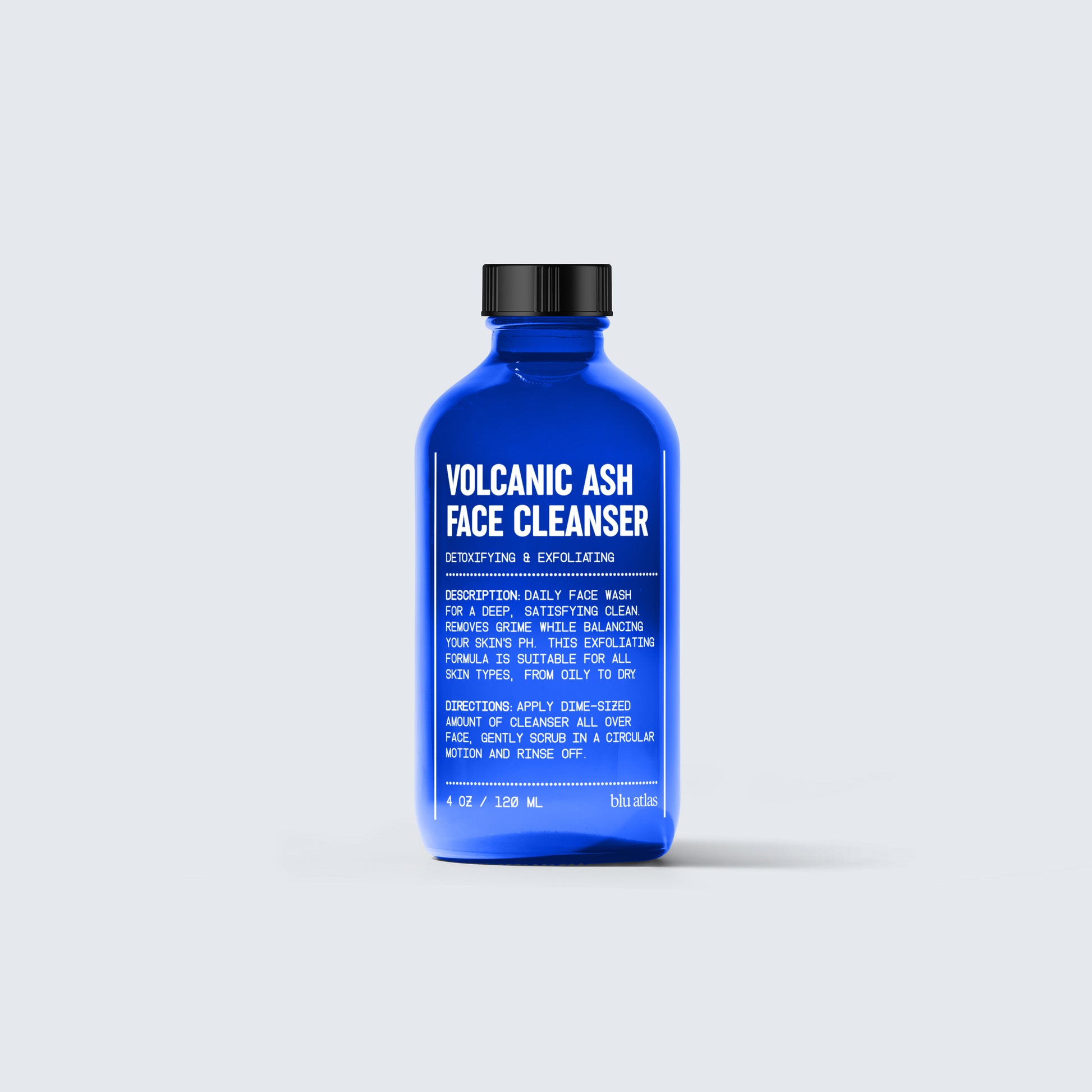 A blue bottle of Blu Atlas Volcanic Ash Face Cleanser showcases white text describing its use and ingredients. This key component of the Advanced Skincare Set naturally revitalizes with volcanic ash, perfectly complementing products such as the Vitamin C Serum for a radiant complexion.