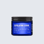 A blue jar labeled Exfoliating Scrub stands proudly in the Blu Atlas Advanced Skincare Set, with product details elegantly printed in white text.