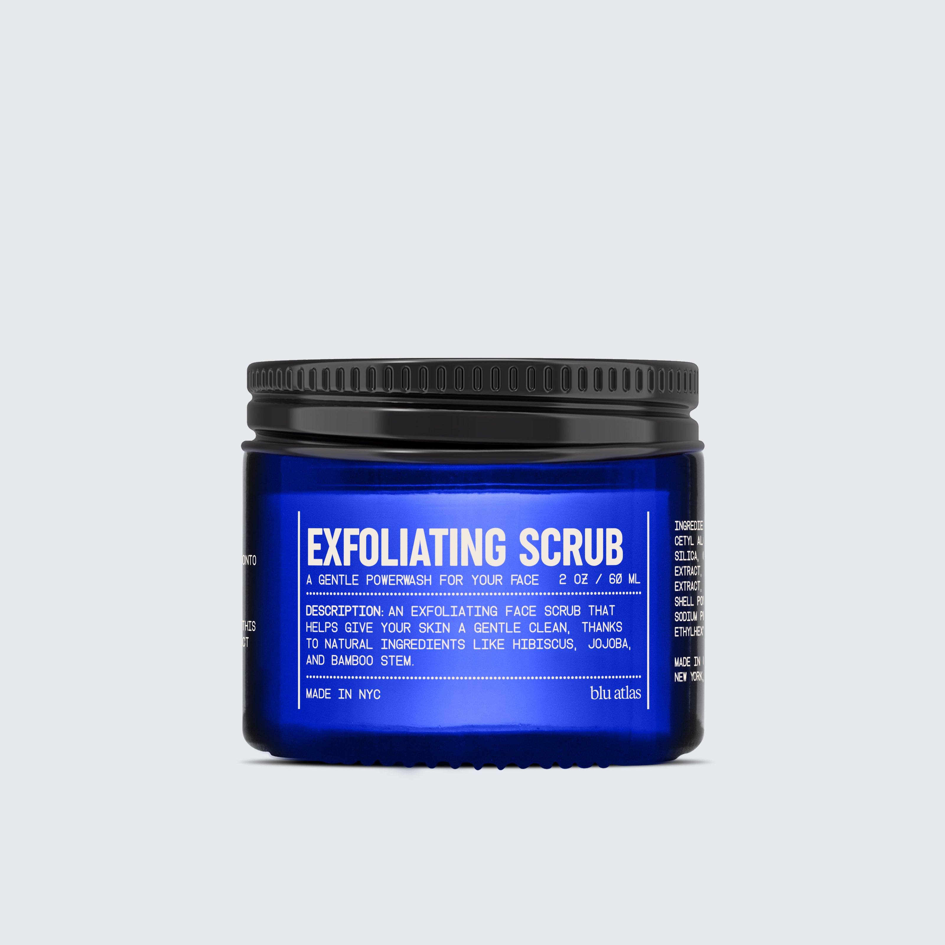 A blue jar labeled Exfoliating Scrub stands proudly in the Blu Atlas Advanced Skincare Set, with product details elegantly printed in white text.
